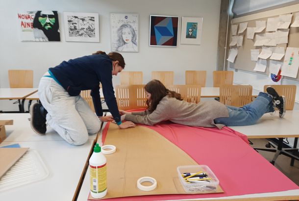 gymnasieelever ligger på bordet og tegner